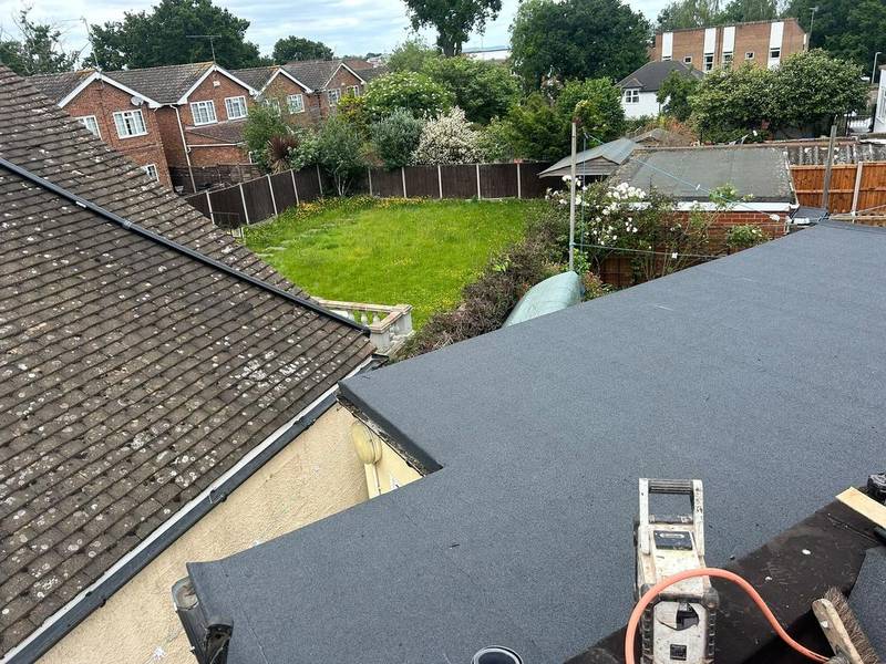 New grey flat roof on a rear extension beside a tiled main roof